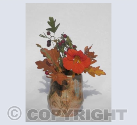 Stoneware vase with orange flower and berries